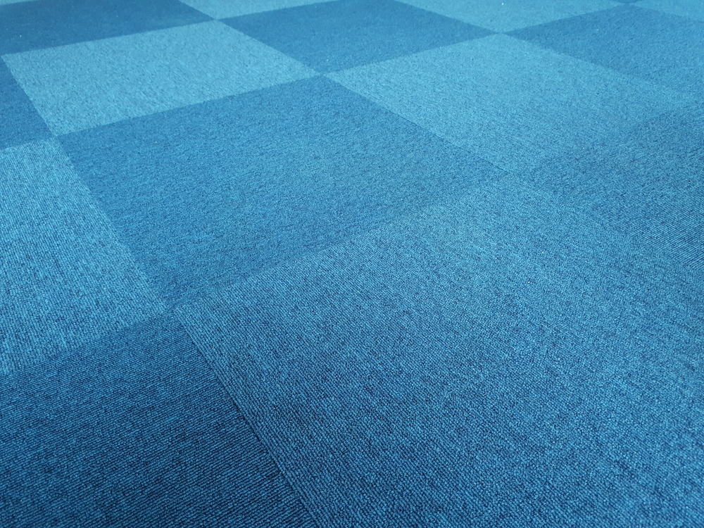 这是一个近距离观察安装了蓝色地毯瓷砖的地板。