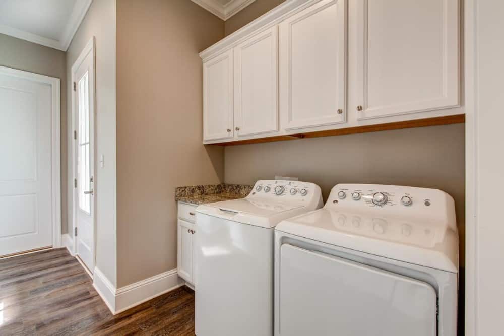 洗衣房配有一台顶装洗衣机和烘干机以及头顶柜。
