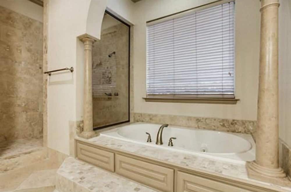 主浴室设有一个优雅的壁龛浴缸，内衬有大理石柱。