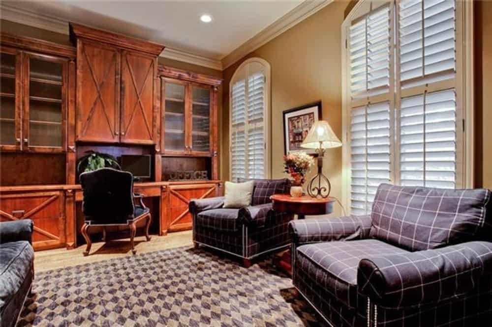 客厅里有格纹扶手椅和一个内置的桌子，上面有头顶的柜子。