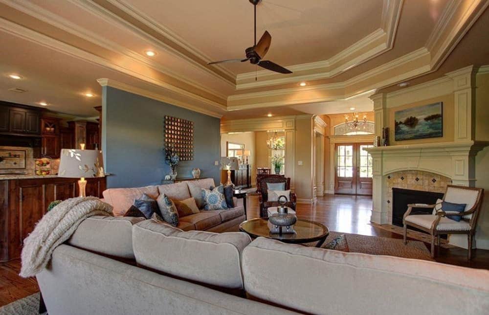 客厅提供米色的部分，一个圆形咖啡桌，和一个角落壁炉，辅以软垫扶手椅。