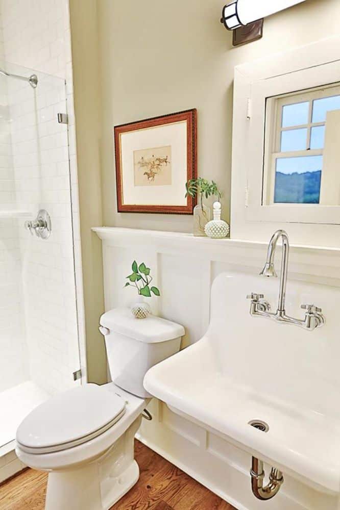 浴室有一个传统的壁挂式水槽，一个马桶，和一个步入式淋浴。