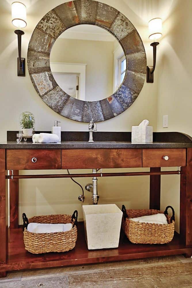 化妆间有一面大圆镜子和一个洗手台，下面有储物篮。