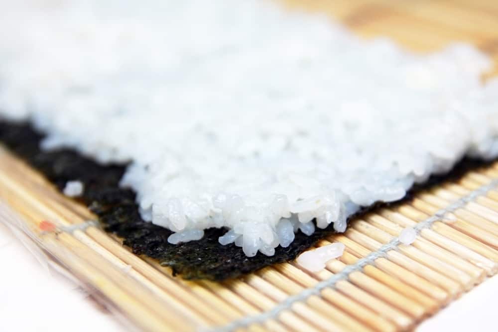 这是一个近距离观察寿司饭上的海藻和垫子组装。