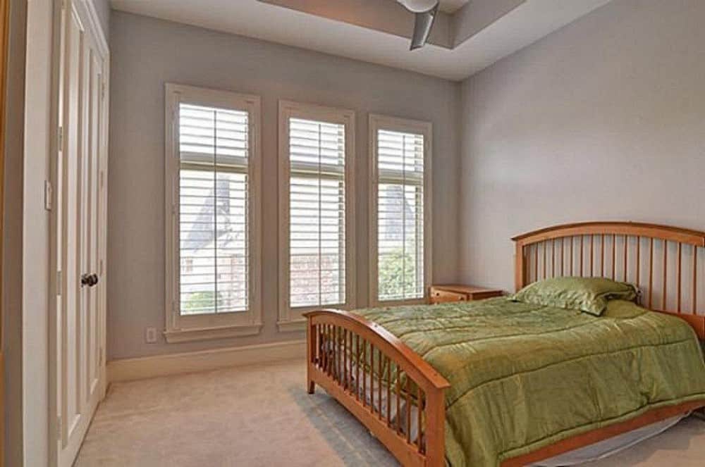 这间卧室有托盘天花板，一张舒适的木床，还有三扇窗户，可以让自然光照进来。