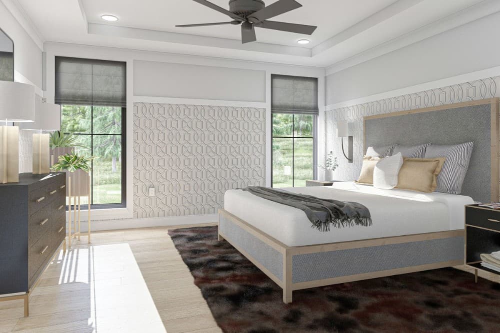 主卧室有托盘天花板，深色梳妆台和舒适的床，床上有图案的地毯。