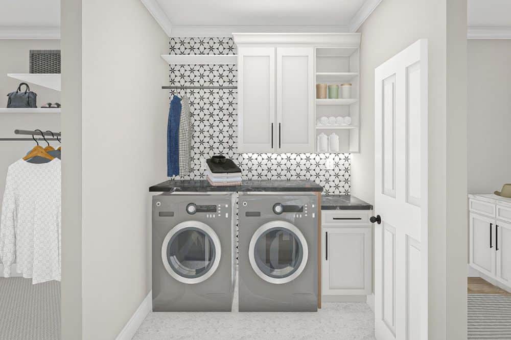洗衣房配有前置洗衣机和烘干机，白色橱柜和黑色大理石台面。