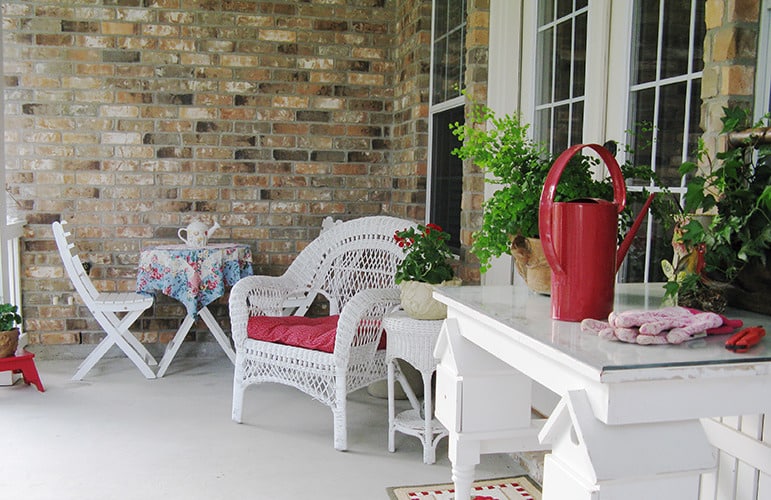 后方玄关充斥着一个圆形餐桌,柳条椅,白色表加上盆栽。
