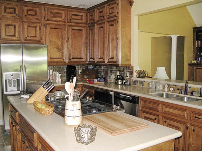 厨房用木制的橱柜,不锈钢电器、炉灶面岛。