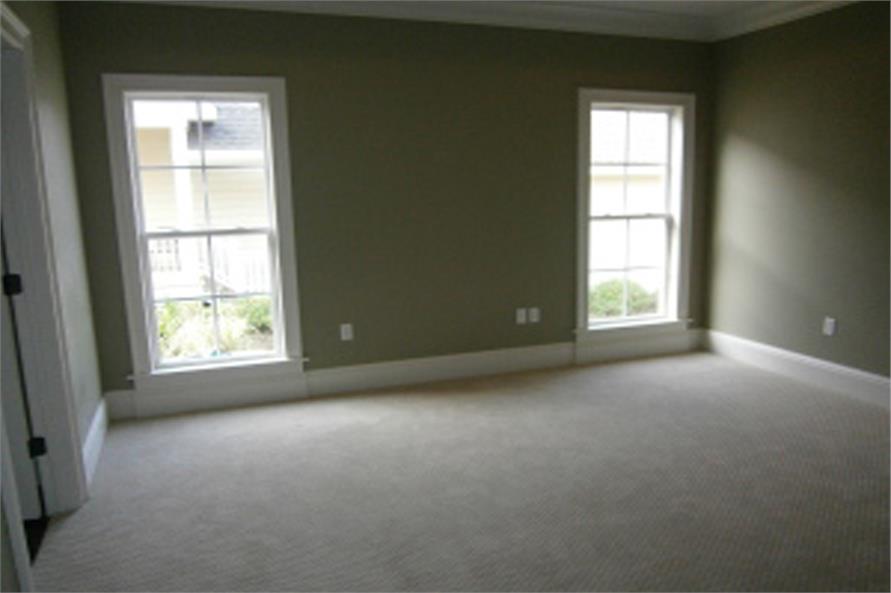 主卧室铺着地毯地板，灰色墙壁衬着白色装饰。