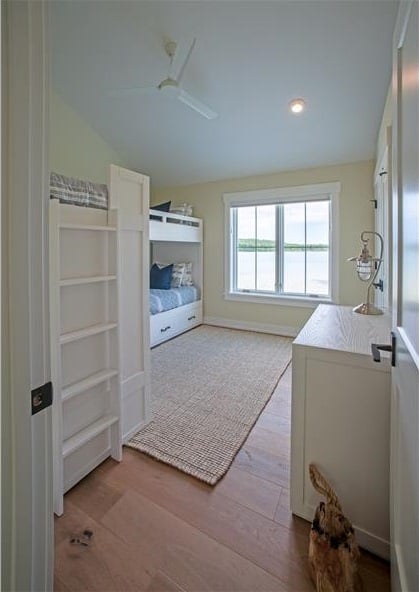 另一间卧室有拱形天花板，地毯地板，还有一张白色双层床。