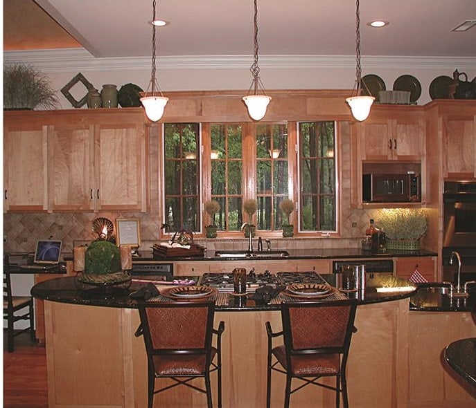 皮革柜台椅和温暖的玻璃挂件与厨房岛相辅相成。