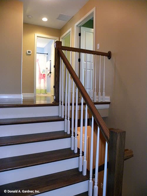 带有木制栏杆的传统楼梯通往楼上的卧室。
