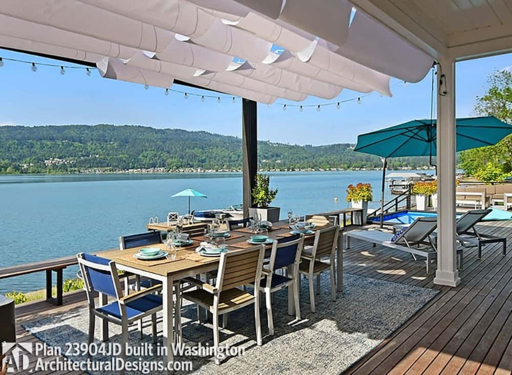 覆盖甲板和一套户外用餐和木制便鞋俯瞰湖。