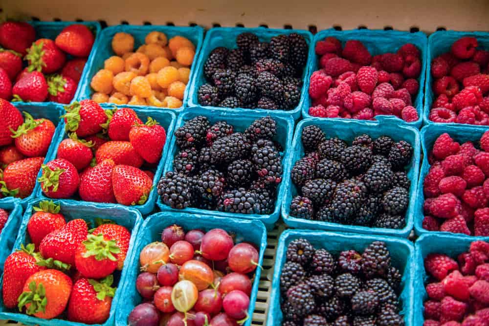 这是一堆在市场上展示和销售的浆果和水果。