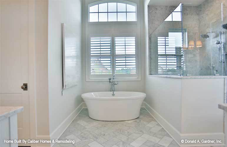 主浴室设有步入式淋浴间和一个放置在百叶窗和拱形横梁下的独立浴缸。