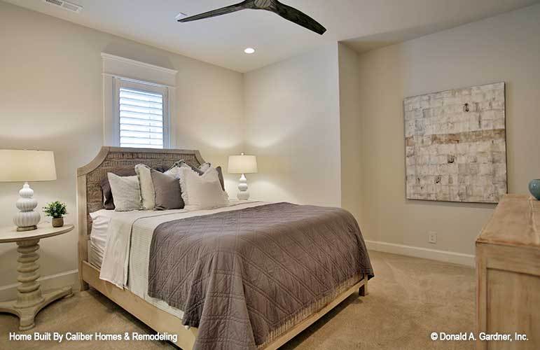 这间卧室里有一张舒适的木床和配套的圆形床头柜，上面铺着地毯。