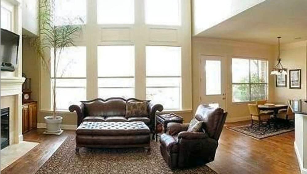 家庭娱乐室有两层楼高的天花板，棕色真皮座椅，大玻璃窗能让充足的自然光线照进来。