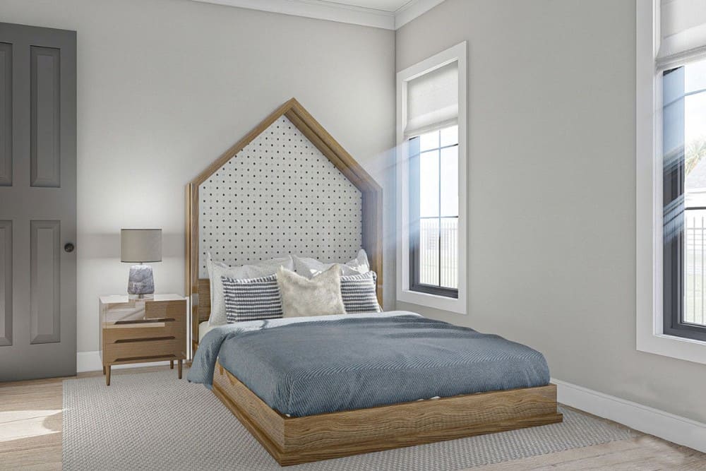 另一间卧室有宽木板地板和一个乡村平台床，突出了定制的三角形床头板。