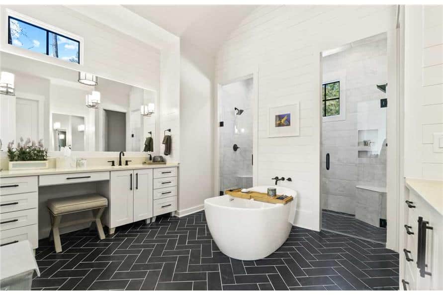 主浴室有一个大梳妆台，一个独立的浴缸，一个宽敞的步入式淋浴间，有两扇玻璃门和两个莲蓬头。