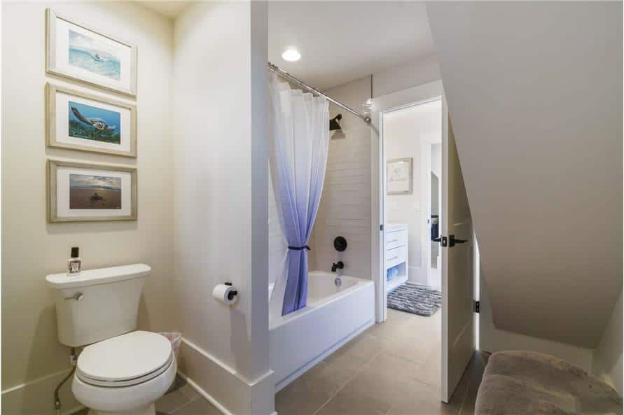浴室包括一个厕所区，装饰着三个装裱好的艺术品。