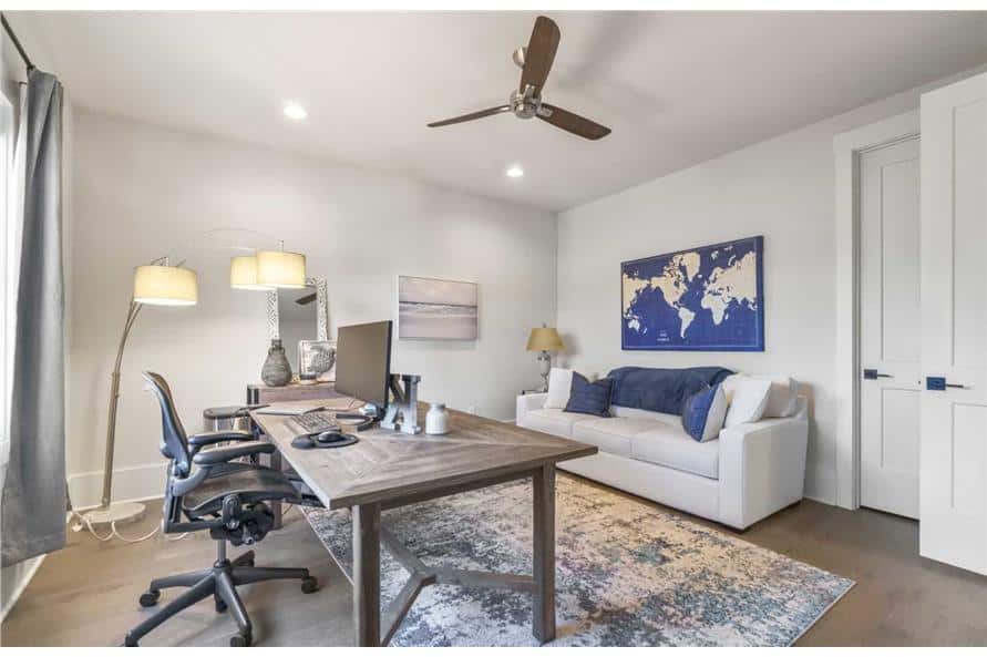家庭办公室，白色组合家具，转椅，一张木桌放在破旧的地毯上。