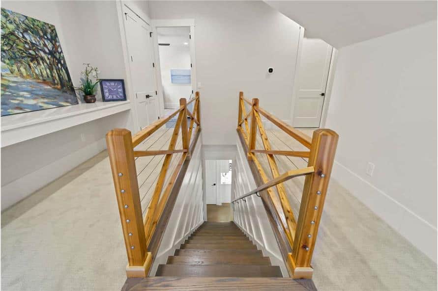 通往二楼的木制楼梯。它的两侧有木栏杆和铺着地毯的走廊。