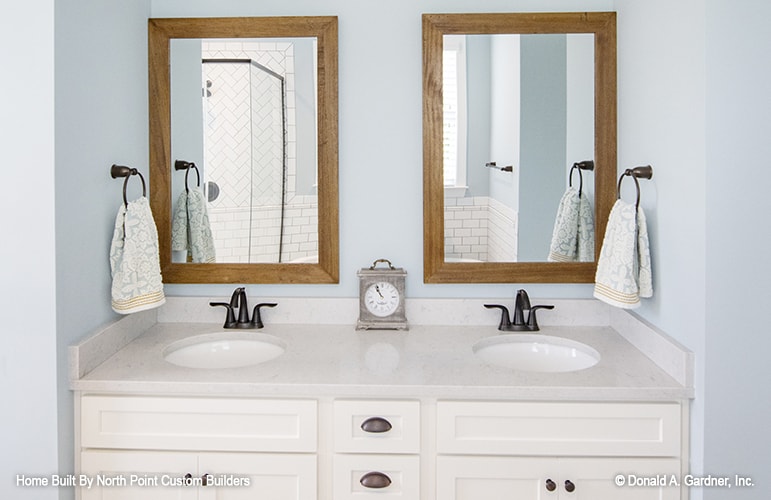 主浴室包括一个双洗手池梳妆台，配有几面木框镜子。