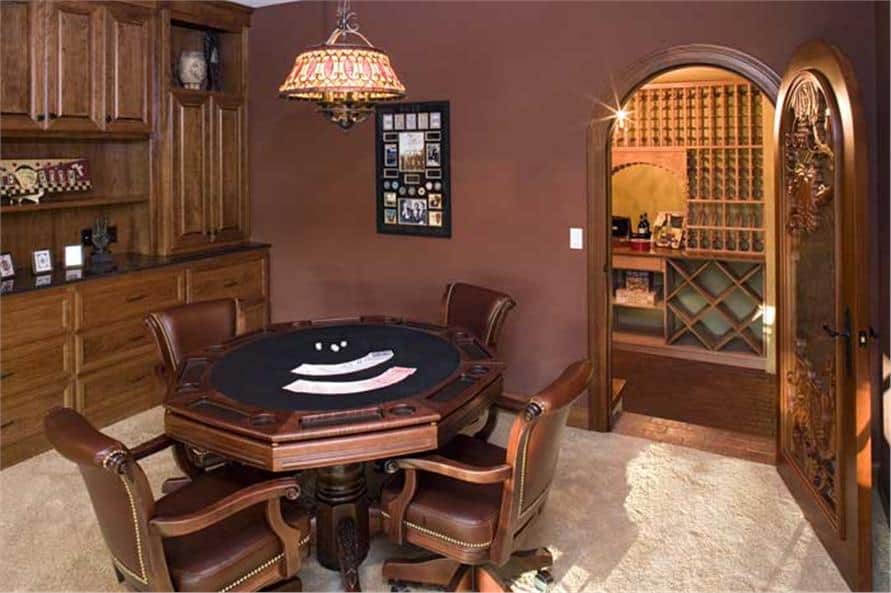 游戏室里有一张牌桌、几个木柜和一个酒窖，酒窖被一扇拱形的门包围着，门上雕刻着复杂的木雕。