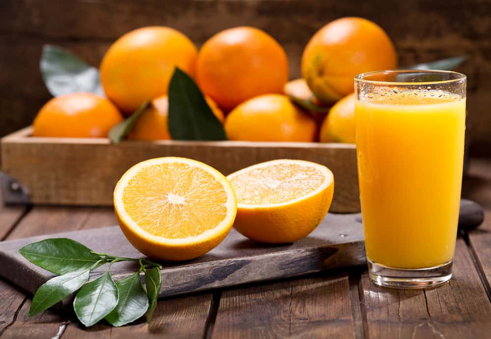 一杯新鲜的橙汁，配上成熟的橙子。