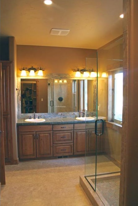 主浴室配备了步入式淋浴间和双洗手池梳妆台，配有一面大无框镜子和温暖的烛台。