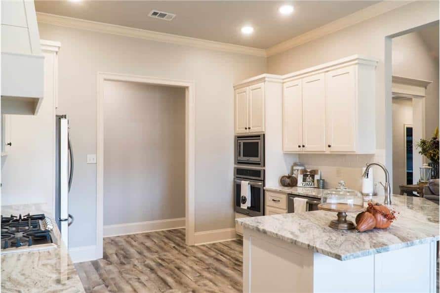 厨房配有白色橱柜，不锈钢电器和内置灶台。