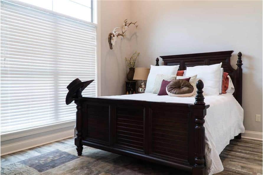 这间卧室有一张深色的木床和一扇巨大的窗户，可以让自然光线充足。