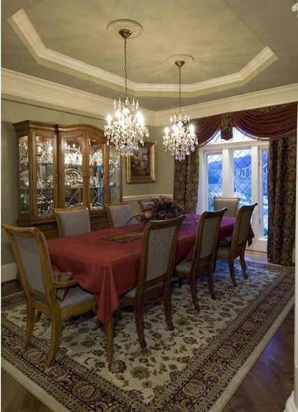 正式的餐厅提供了一个瓷器柜，一个8座的餐厅，和一对水晶吊灯挂在托盘天花板。