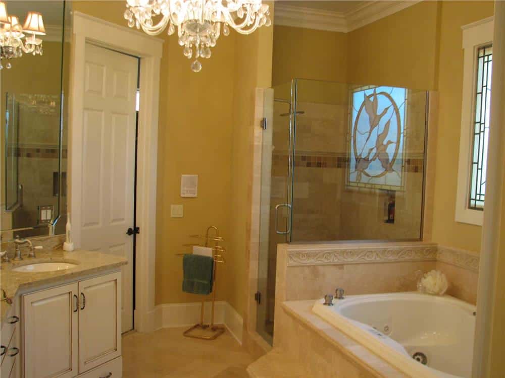 仔细看看浴缸和步入式淋浴，并配有黄铜毛巾架。