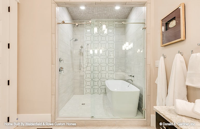 步入式淋浴与滑动玻璃门,chrome装置,和一个独立的浴缸。