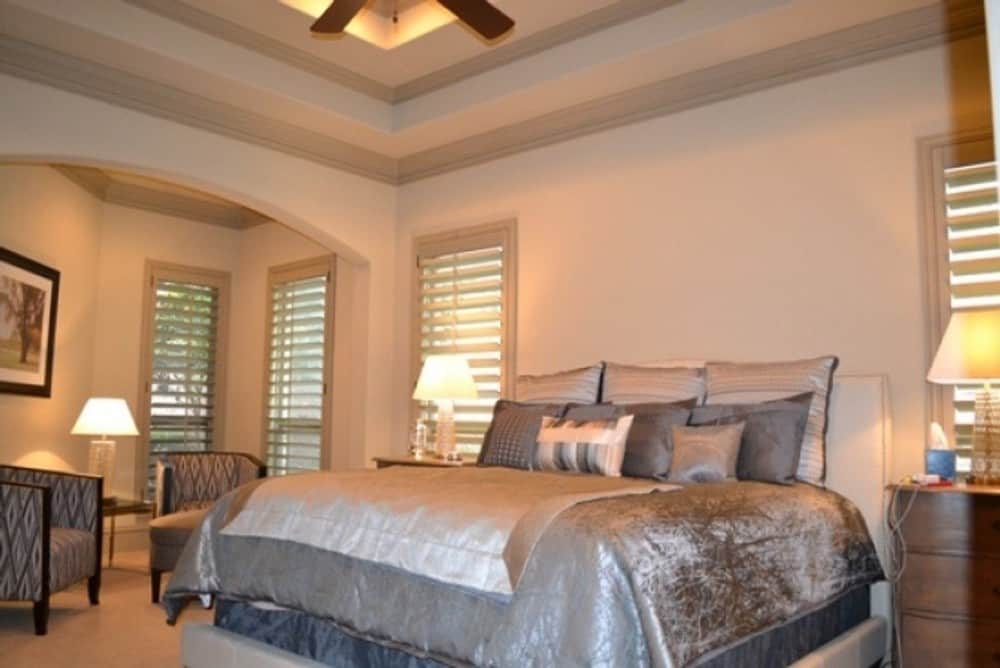 主卧室功能一步天花板,一个舒适的软垫床,坐在区域框架装饰拱门。