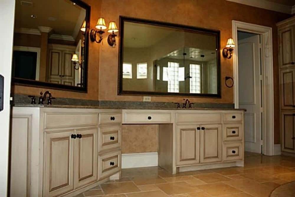 主浴室设有一个大的双水槽梳妆台，中间有一个化妆台。它的顶部有镜框镜子和温暖的烛台。