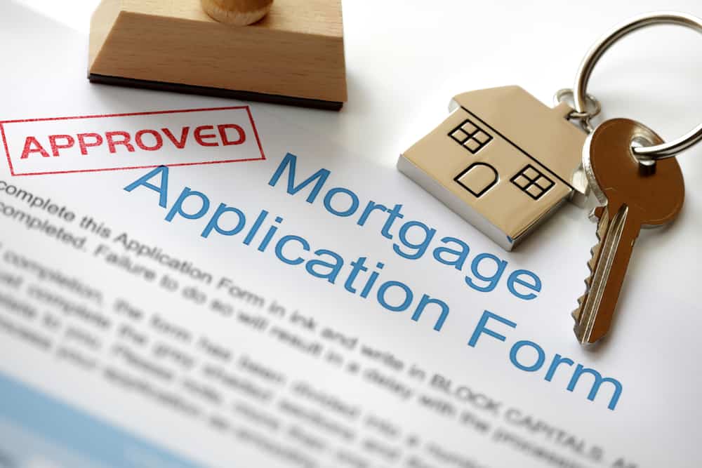 这是一个仔细看批准的抵押贷款申请表与房屋钥匙。