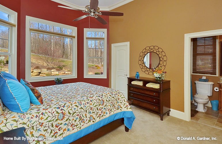 另一个卧室地毯地板、多色的墙壁和一个私人浴室。