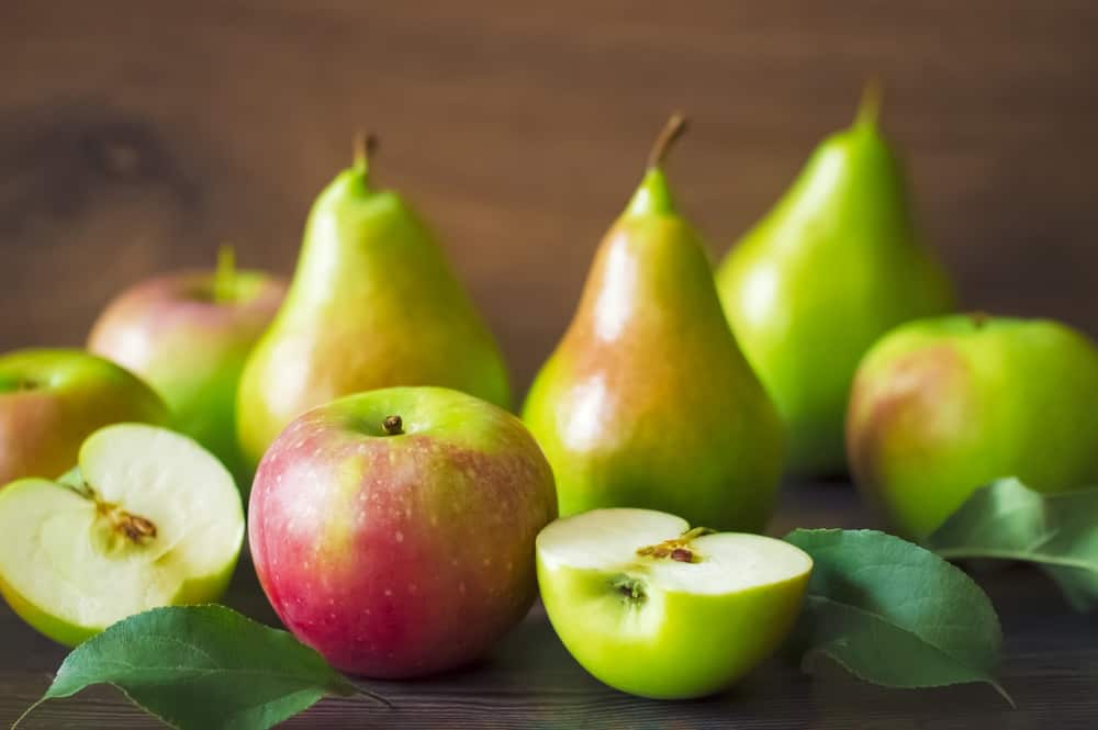 这是一张木桌上的梨和苹果。
