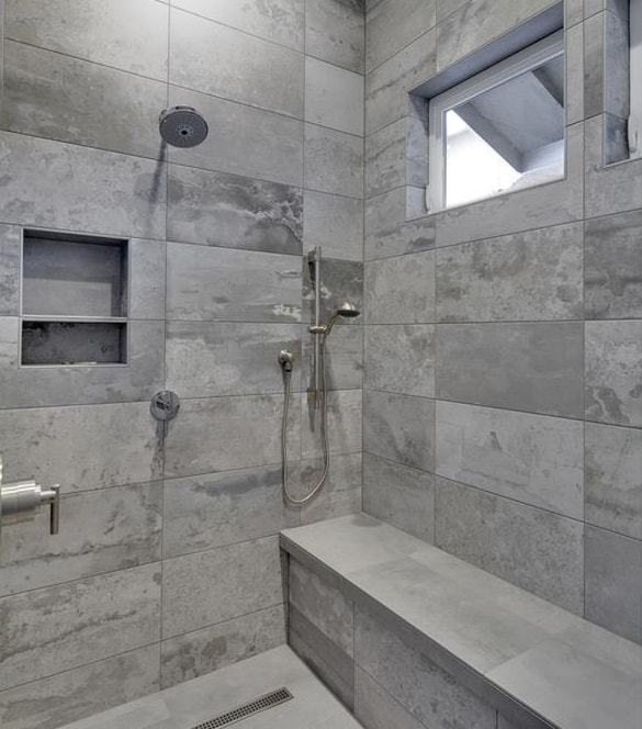 步入式淋浴配有镀铬固定装置，瓷砖墙壁，插图架和内置长凳。