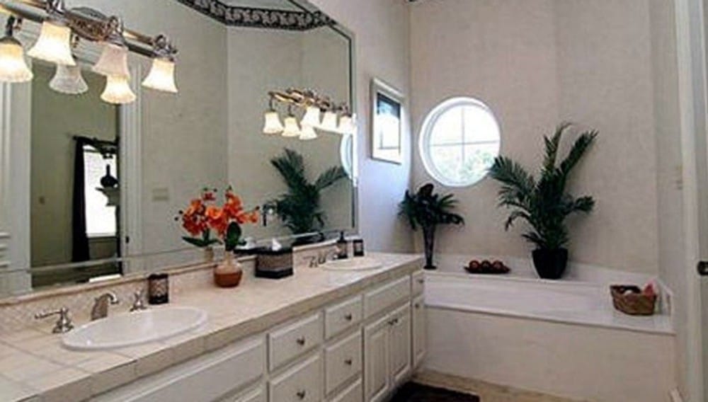 主浴室设有一个落地式浴缸和一个双洗手台，用温暖的玻璃壁灯照明。