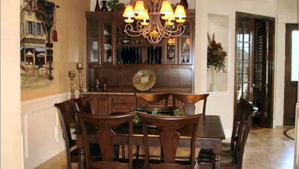 正式的餐厅，内置橱柜和配套的木制餐厅，由温暖的吊灯照明。