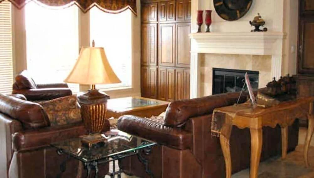 这间家庭娱乐室包括一座玻璃围成的壁炉和木质的内置家具。