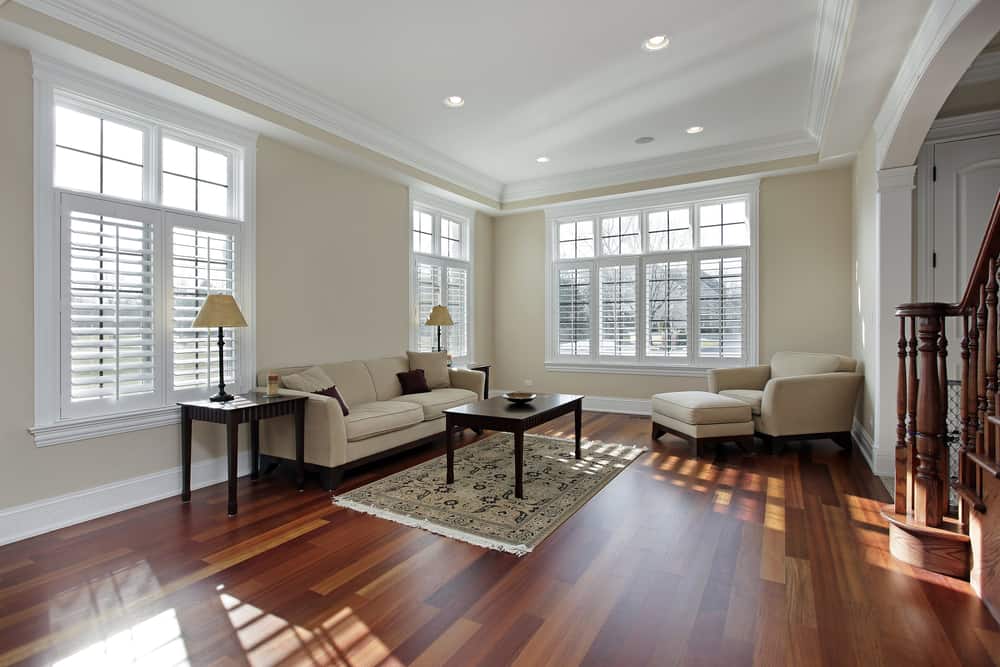 明亮的客厅，樱桃木地板上的深色木家具。