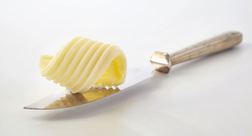 特写的主黄油刀上面有黄油卷。
