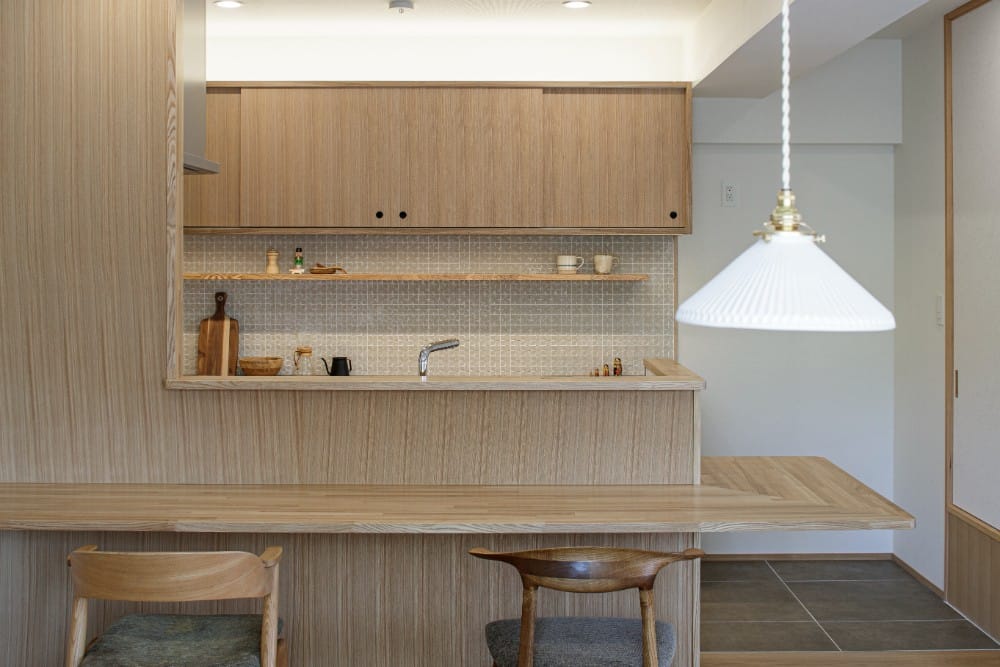 白色厨房内部，木地板。极简主义风格的轻木吧台和橱柜作为背景。