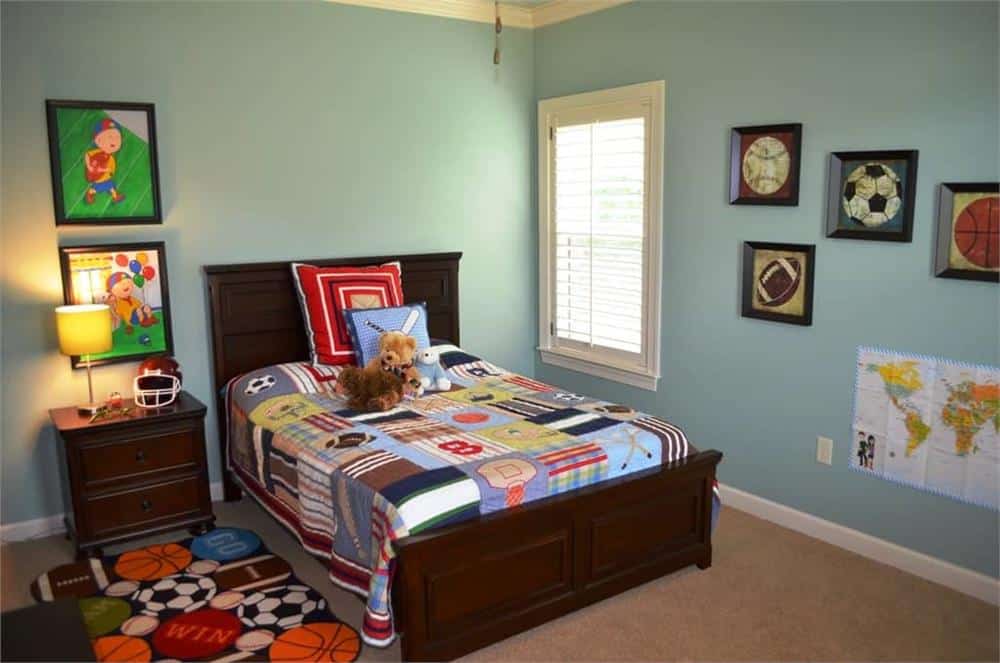 孩子的卧室有木制家具，地毯地板，蓝色的墙壁装饰着镶框的艺术品。