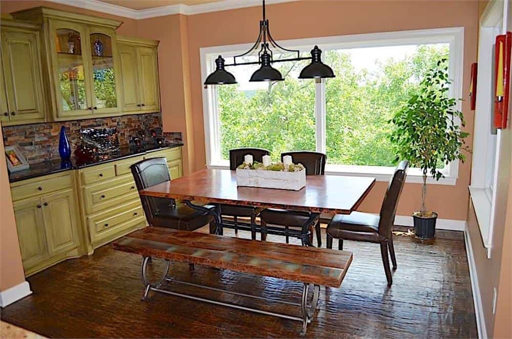 早餐角落里有一个内置的自助餐柜和一张木制餐桌，周围是配套的长凳和皮革软垫椅子。